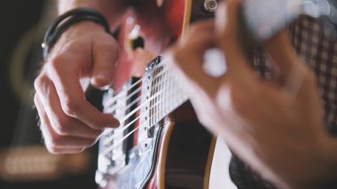 Erkek müzisyen gitar, eller yukarı, gitar klavyesine odak yakın çalıyor.