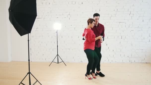 Mujer de mediana edad y hombre joven está bailando kizomba en el estudio, de cerca — Vídeo de stock