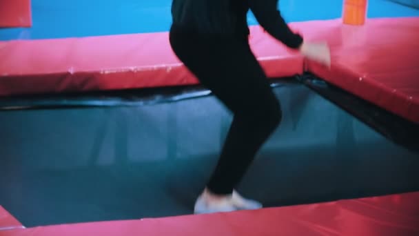 若い女性の曲芸師はアクロバティックなトリック - トランポリン ホールでジャンプを実行スローモーション — ストック動画