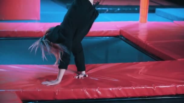 Woman acrobats perform acrobatic tricks - jumping in a trampoline hall, slow-motion — Stock Video