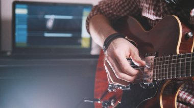 Genç müzisyen oluşturur ve bilgisayar ve klavye kullanarak gitar çalmak soundtrack kayıtları