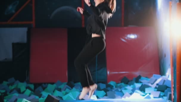 Acrobati donna eseguire acrobazie saltando in una sala trampolino, rallentatore — Video Stock