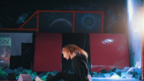 Молодая привлекательная женщина акробаты прыгать в батуте зал, замедленной съемки — стоковое видео