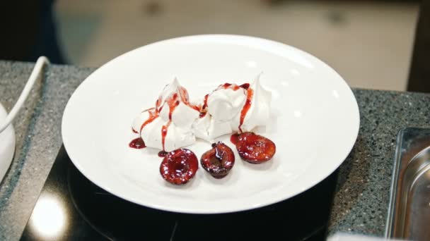 La mujer en la cocina agrega confitura de frutas para el postre pastel Pavlova - de cerca — Vídeo de stock