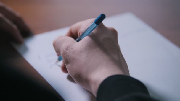 Рука человека пишет текст ручкой на бумаге — стоковое видео
