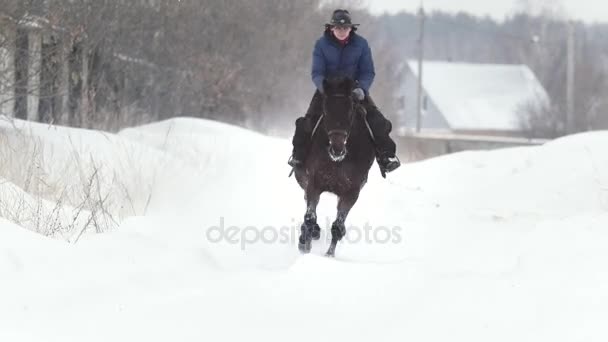 Pferdesport - Reiterin galoppiert auf schneebedecktem Feld — Stockvideo