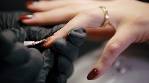 Vista de cerca de uñas de pulido - hembra obtener manicura profesional en salón de belleza — Vídeo de stock