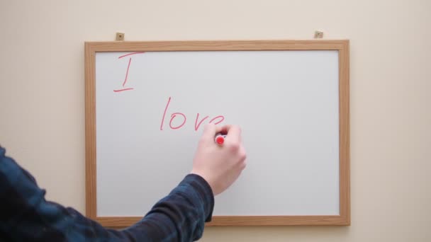 Hand schrijven en wissen van het opschrift ik hou van je met rode marker op whiteboard — Stockvideo