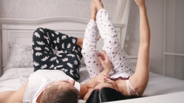 Feliz alegre amante pareja haciendo selfie en la cama, joven atractivo chico y chica mintiendo en pijama — Vídeos de Stock