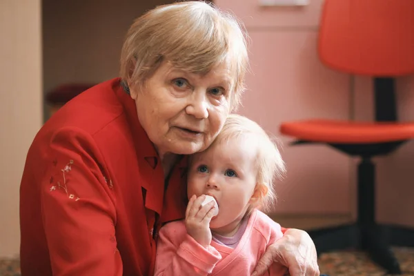 Портрет маленькой милой девочки с бабушкой дома — стоковое фото