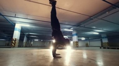 Genç acrobat yer altı otoparkı, egzersiz - yavaş hareket var