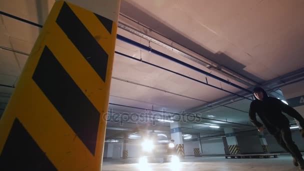 Молодий чоловік акробат показує трюки сальто на підземному паркінгу — стокове відео
