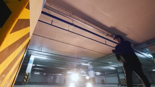 Man acrobat shows tricks somersault at underground parking — Stock Video