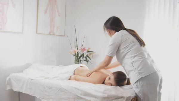 Massaggio per attraente bionda giovane donna in camera spa — Foto Stock