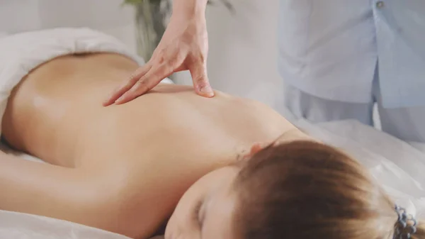 Blonde young woman model receiving relaxing massage in spa room — Stock Photo, Image