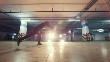 Genç erkek, yer altı otoparkı - yavaş hareket akrobatik egzersiz yapıyor