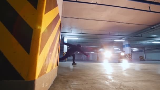 Αργή κίνηση πυροβολισμό ακροβατικό άντρα εκτελεί κόλπα στο υπόγειο χώρο στάθμευσης — Αρχείο Βίντεο