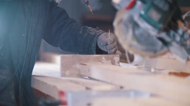 Schrijnwerkerij - werknemer timmerman zet de schroeven in een houten plank — Stockvideo