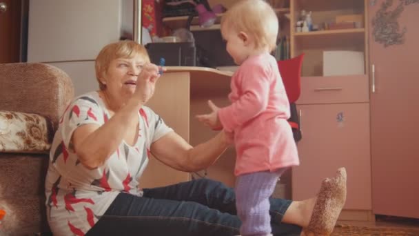 Babcia z jej wnuczka, uśmiechając się, rozmawia, odtwarzanie i czesanie — Wideo stockowe
