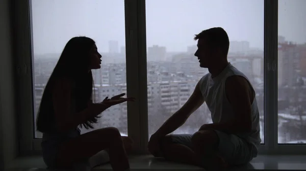 坐在窗台上的年轻夫妇, 感情上的谈话, 争吵和指手划脚 — 图库照片