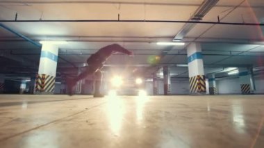 Garaj, parkour akrobatik öğeleri, ağır çekim duvarından bir flip yapıyor freerunner şık genç adam