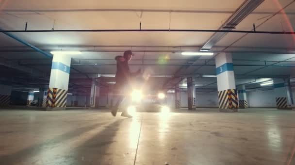 Jonge man doen acrobatische sporten in ondergrondse parking - vertraagd — Stockvideo