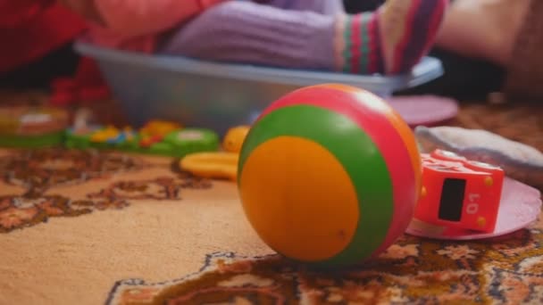 Cute little girl and her grandmother playing together sitting on floor, focus on toys — Stock Video