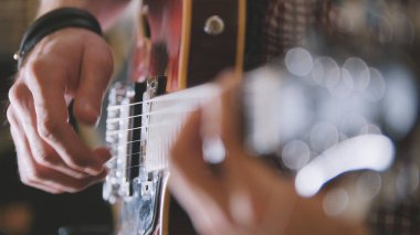 Erkek müzisyen gitar, eller yukarı, gitar klavyesine odak yakın çalıyor.