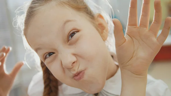 Маленькая девочка смешно и показывает в камеру свиной нос и язык — стоковое фото