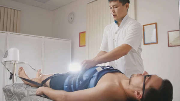 Врач-остеопат выполняет процедуру, растягивая позвоночник, хиропрактику, азиатскую тибетскую медицину — стоковое фото