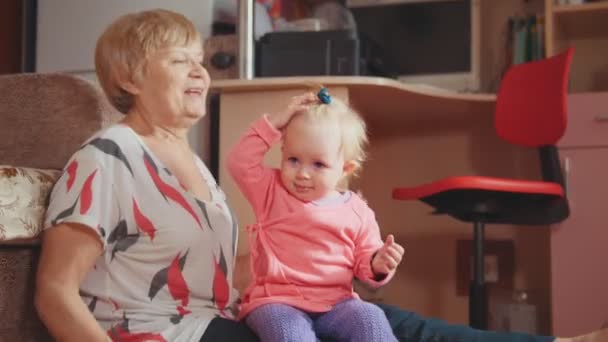 Nonna con la sua graziosa nipote, sorridente, parlando, giocando e pettinando — Video Stock