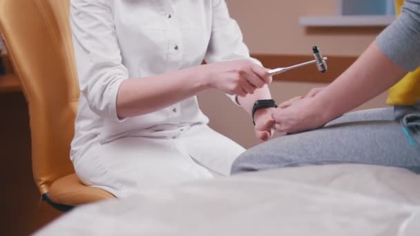 Neurologe untersucht den Patienten, der mit einem Hammer auf Knie und Arme schlägt — Stockvideo