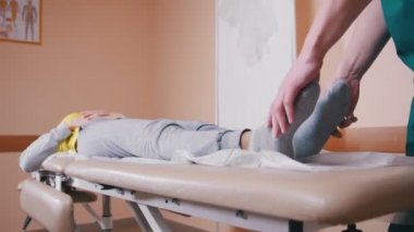 Masaj ve masaj masanın üzerinde yatan genç bir kadın inceleyerek el ile terapist