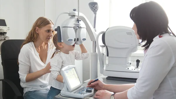 Kinderaugenheilkunde - Augenoptiker untersucht Auge eines kleinen Mädchens — Stockfoto