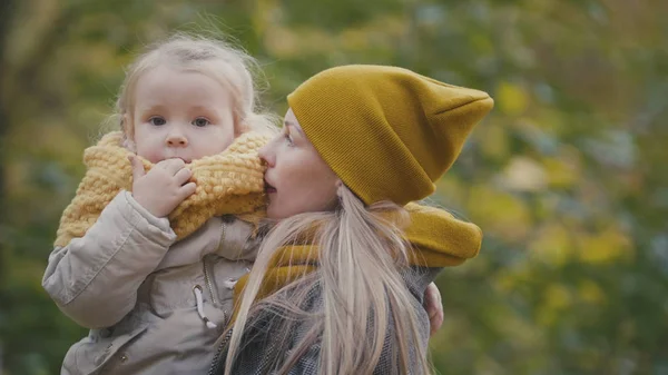 Bella figlioletta con la sua mamma passeggia nel parco autunnale — Foto Stock