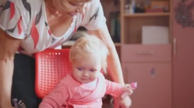 Bir sandalyenin üstüne iniş, oyun ve penye şirin huzursuz torunu ile büyükanne