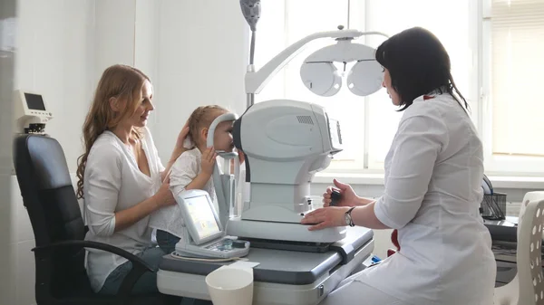 Augenarzt in der Klinik überprüft das Sehvermögen kleiner Mädchen - Kinderaugenheilkunde — Stockfoto