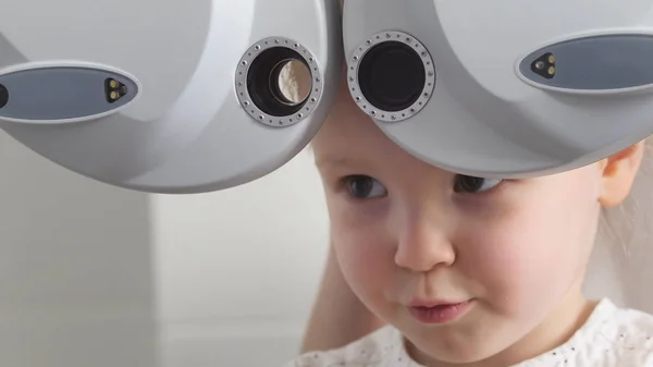 眼科诊所-可爱的金发小姑娘检查视力视力，关闭了 — 图库照片