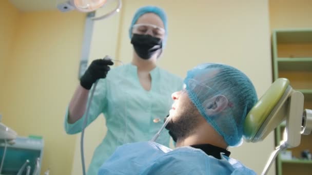 Médico y paciente en el consultorio dental, lavándose la boca — Vídeo de stock