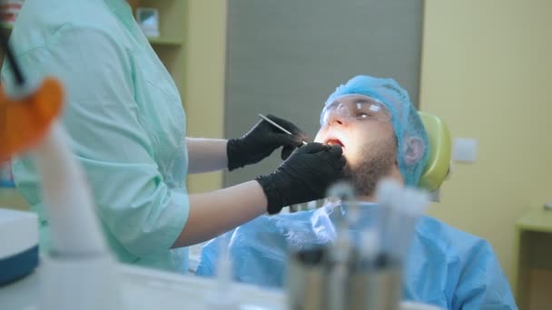 Arts en patiënt in de tandheelkundige kantoor, inspectie mans mond — Stockvideo