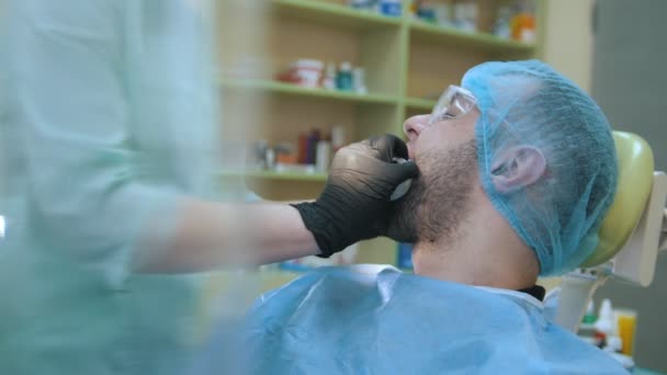 Doctor and patient in the dental office, retractor placement — Αρχείο Βίντεο