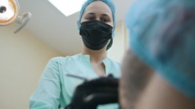 Doktor stomatologist ve hasta diş ofis, teftiş ve inceleme sonda ile ağız