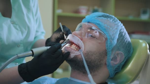 Médico y paciente con dilatador labial en consultorio dental, pulido con cepillo estomatológico — Vídeos de Stock