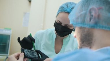 Stomatologist ve diş ofiste, danışmanlık, açıklama ve elektronik cihazların x-ışını kullanarak gösterilen hasta