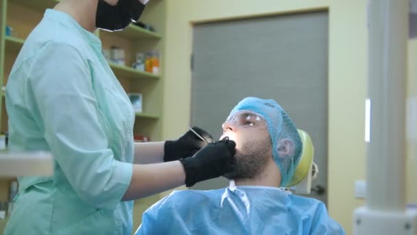 Médico y paciente en el consultorio dental, examen de la boca — Vídeo de stock