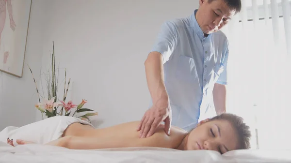 Doctor osteopat y paciente - mujer joven acostada en la camilla de masaje - tratamiento médico — Foto de Stock