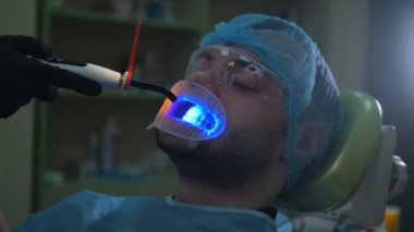 Doktor ve hasta ile dudak DİLATÖR diş ofiste, ultraviyole ışık ve turuncu koruyucu ekran ile Temizleme