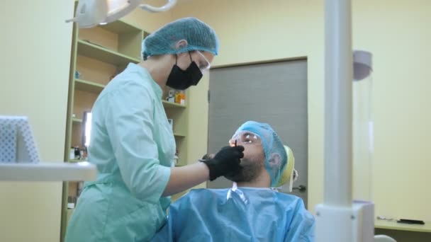 Medico e paziente nello studio dentistico, ispezione ed esame della bocca — Video Stock