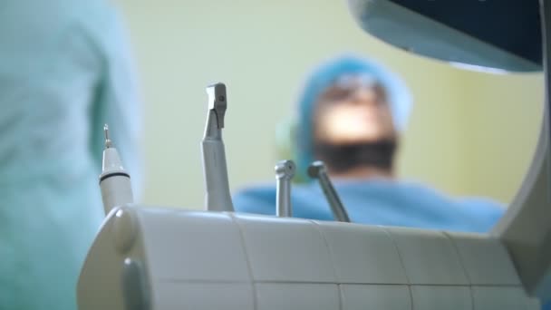 Arzt und Patient in der Zahnarztpraxis, Munduntersuchung, medizinische Instrumente und Bohrer im Vordergrund — Stockvideo