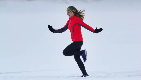 Młodych kobiet sportowiec, uruchomiona w zimie po śniegu — Zdjęcie stockowe